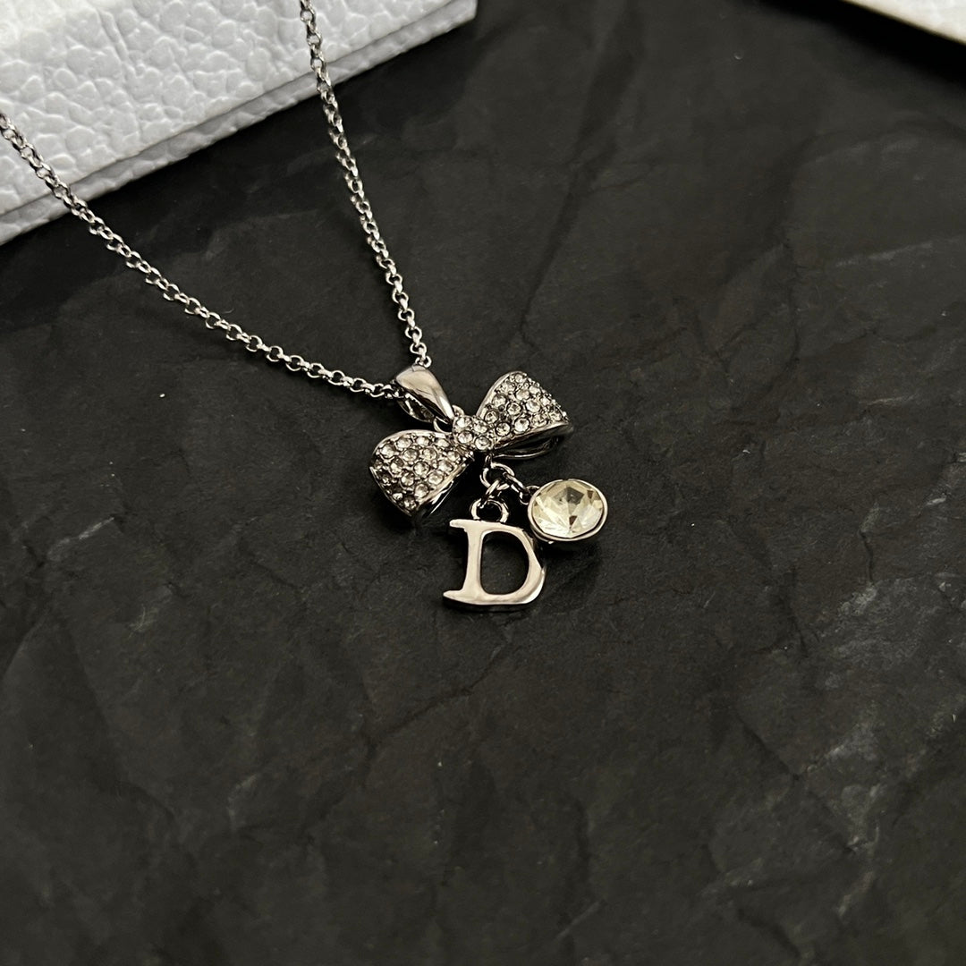 Dior bow necklace, silver-tone chain with rhinestone bow and D drop charm