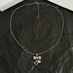 Dior bow necklace, silver-tone chain with dangling rhinestone bow and D pendant