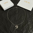Dior bow necklace with long chain and rhinestone bow, letter D charm