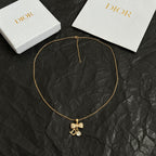 Gold-tone pendant necklace with butterfly charm and letter D at center