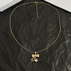 Gold-tone pendant necklace with butterfly charm and letter D center pendant
