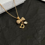 Gold-tone pendant necklace with layered charms and letter D pendant