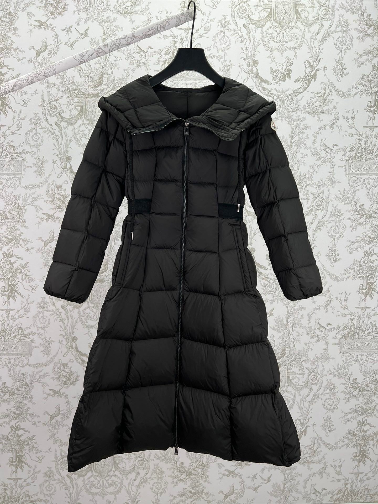 Black long puffer coat with hood, zip front, and belted waist