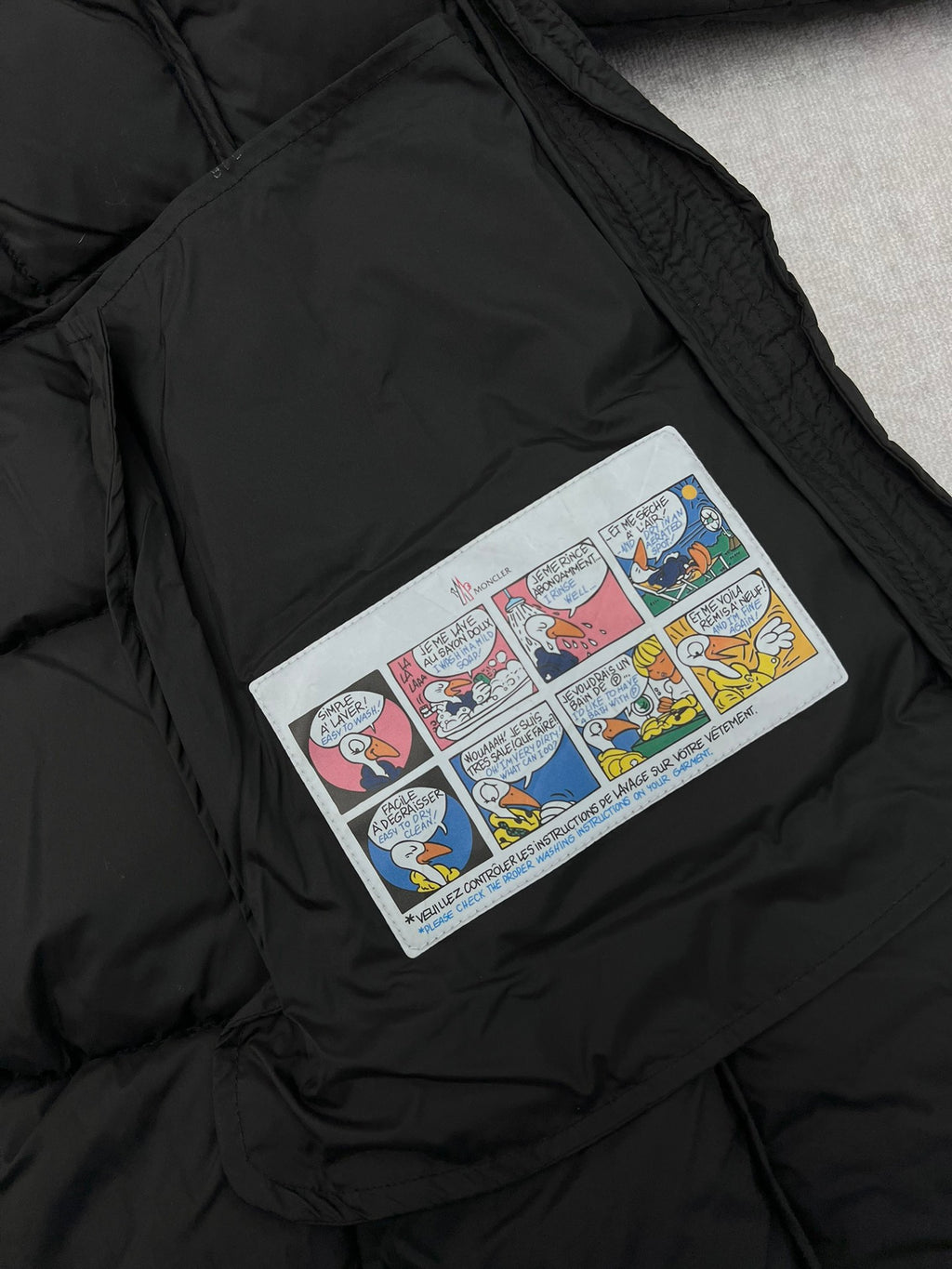 Comic-style patch on black puffer coat chest