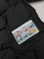 Comic-style patch on black puffer coat chest