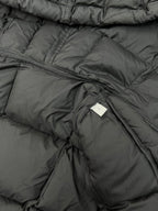 Inside lining and stitching on black puffer coat with label tab