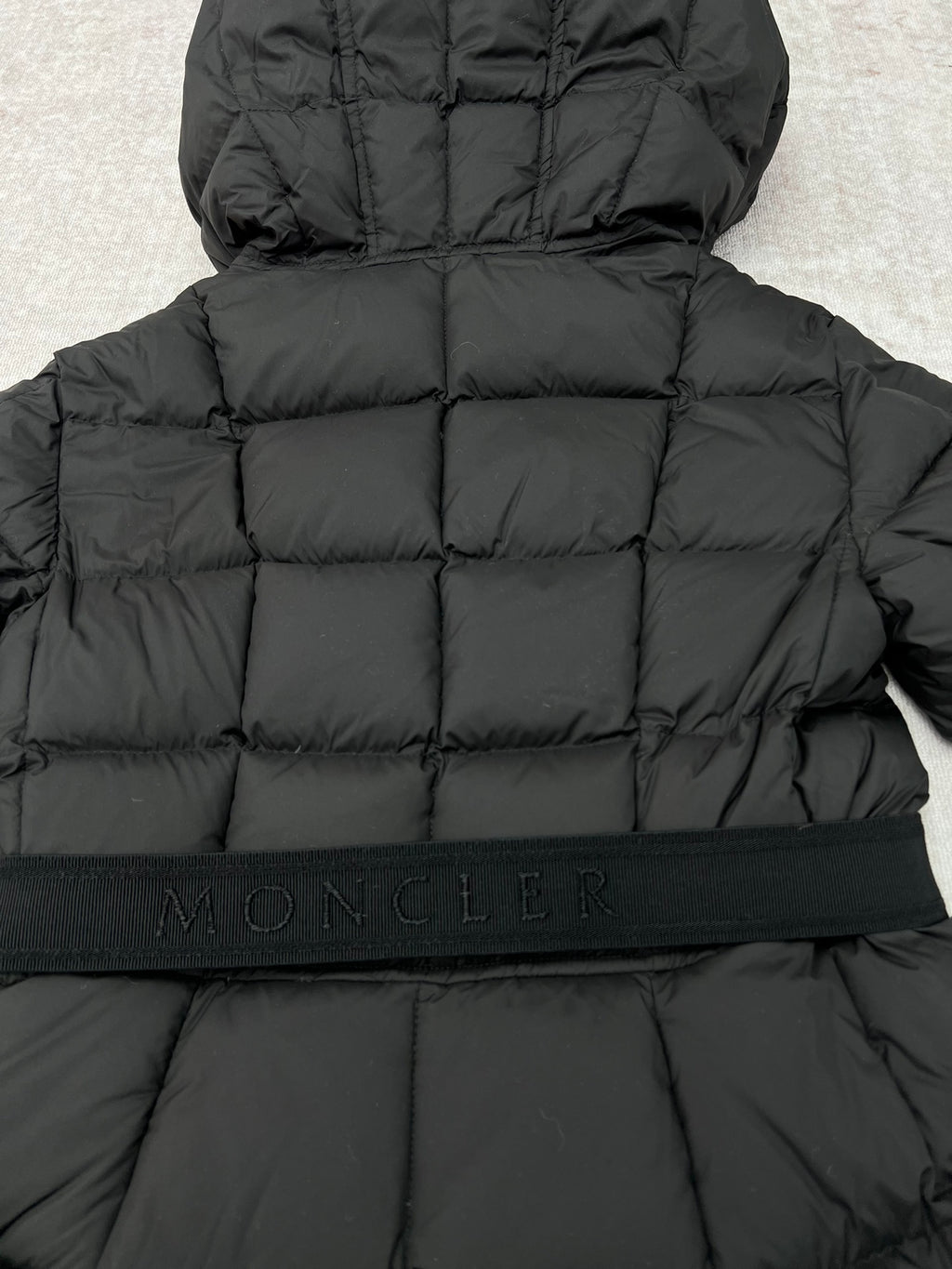 Moncler logo waistband on black long puffer coat