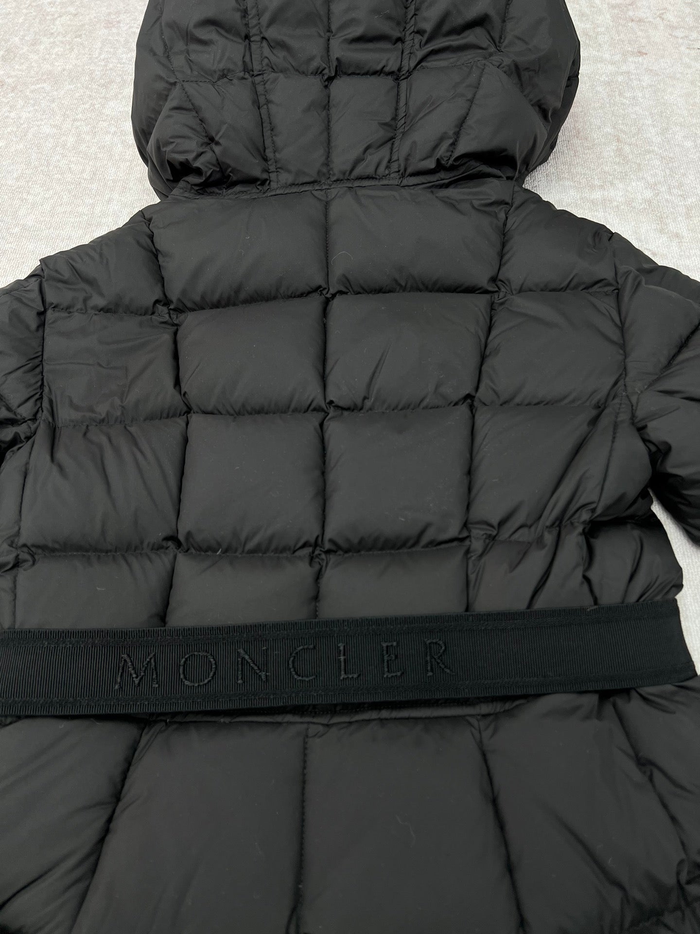 Moncler logo waistband on black long puffer coat