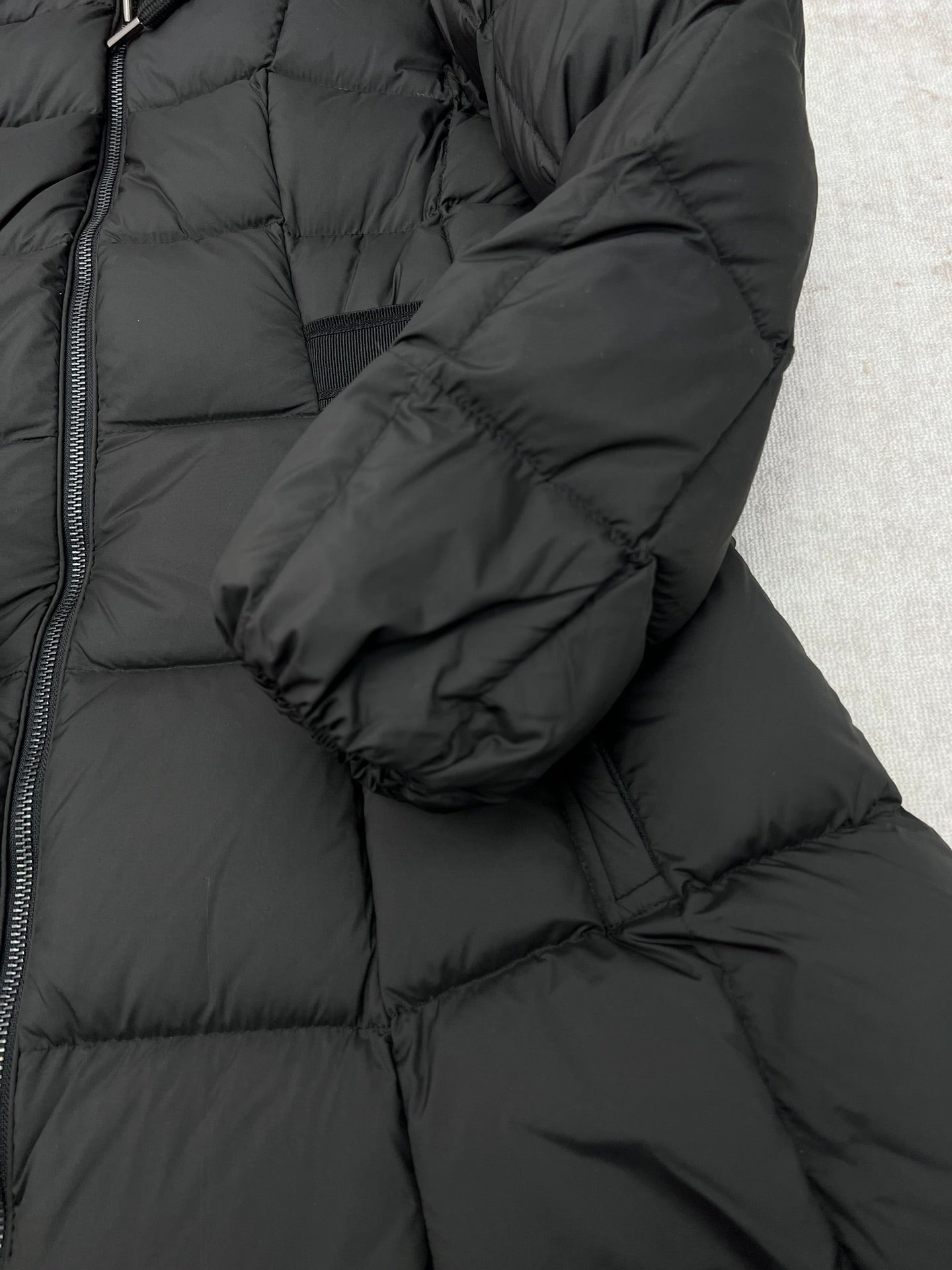 Dark puffer coat sleeve cuff and quilted padding detail