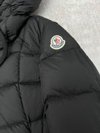 Moncler logo patch on black puffer coat shoulder