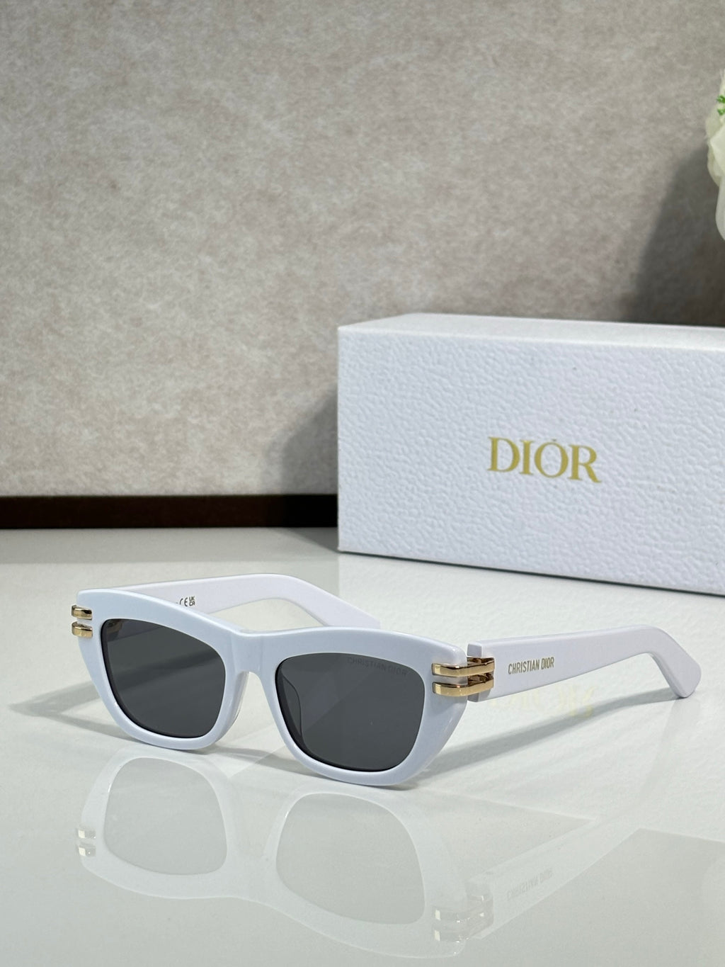 Dior sunglasses, white frame with dark lenses and gold logo temple tips