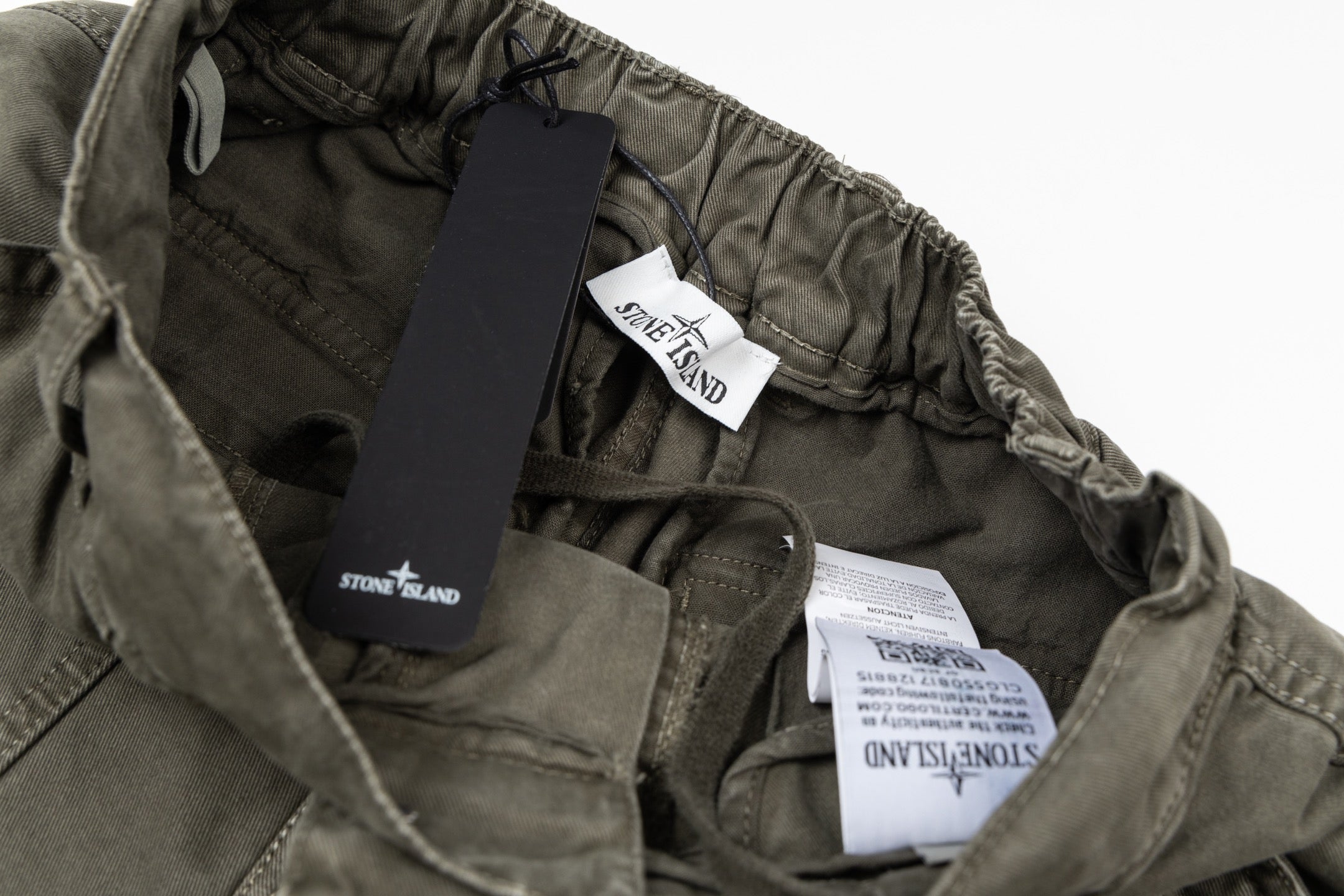 Olive drawstring pants with Stone Island branded labels and elastic waist