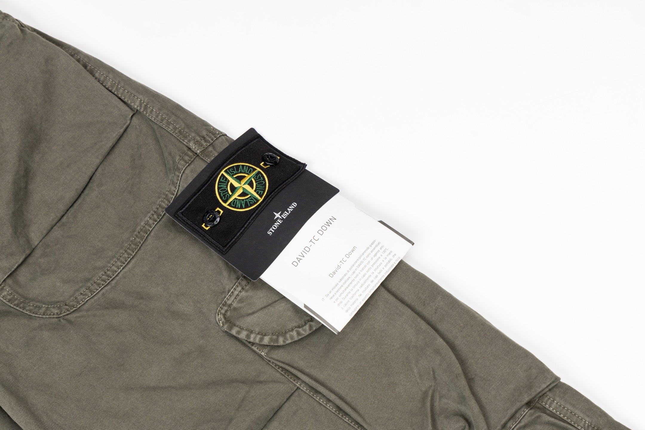 Stone Island olive cargo pants with black label patch on a front pocket