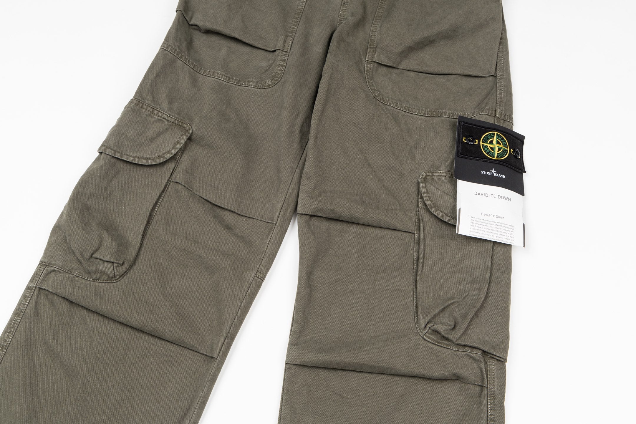 Stone Island olive cargo pants close-up of side pockets and brand tag on leg