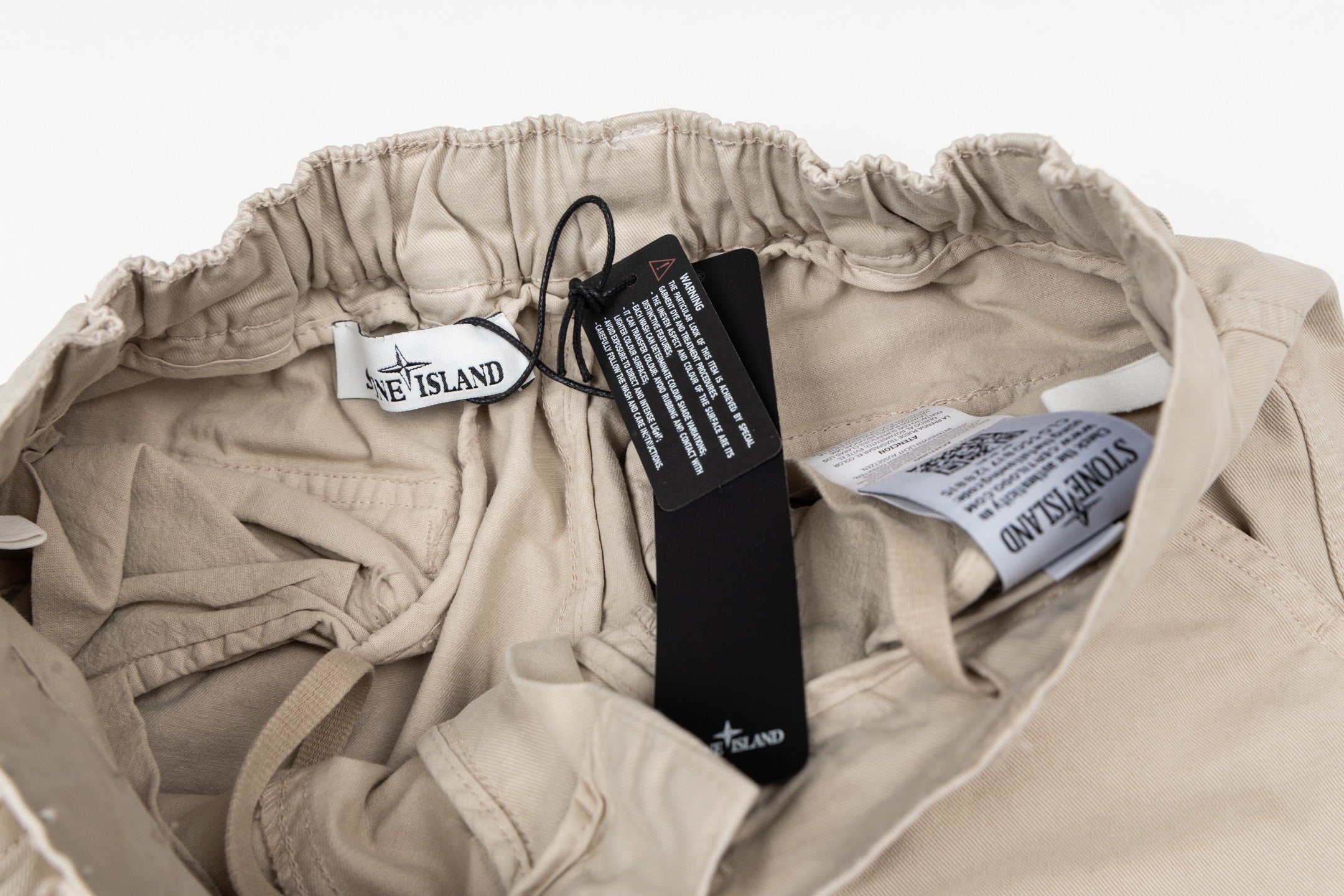 Stone Island beige cargo pants with elastic waist and care labels inside