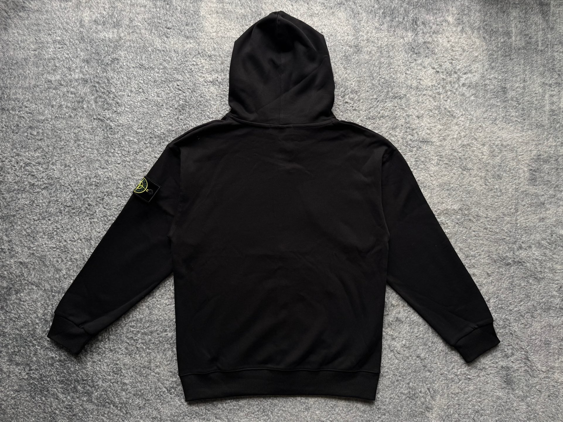 Black zip-up hoodie with hood, drawstrings, and pouch pocket, back view