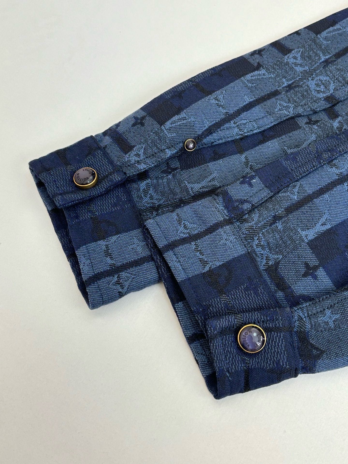 Louis Vuitton blue plaid trousers close-up with button details and flap pockets