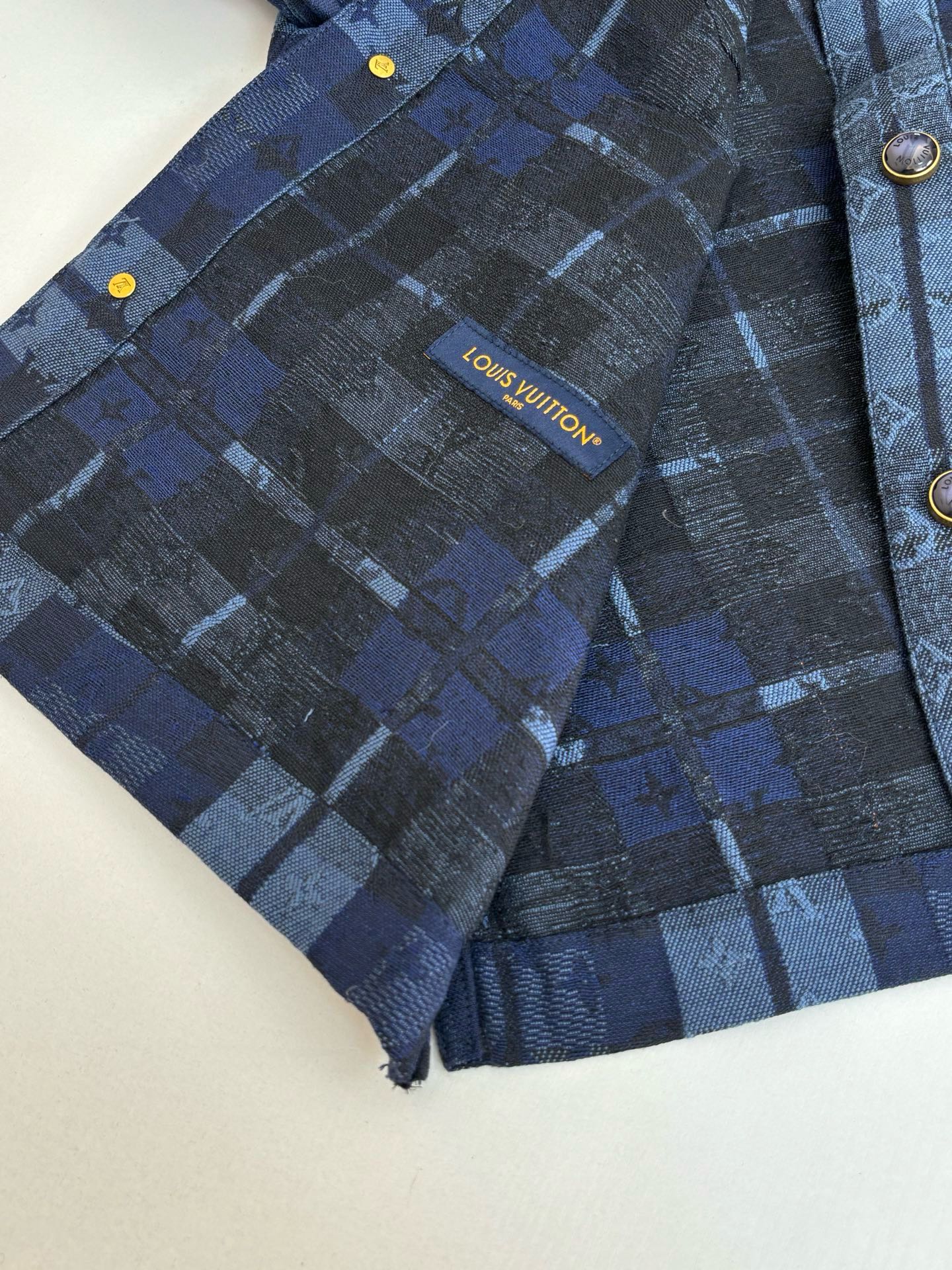 Louis Vuitton blue plaid jacket inner label with gold-tone button accents