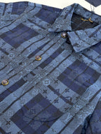 Louis Vuitton blue plaid jacket close-up with monogram pattern and round gold buttons