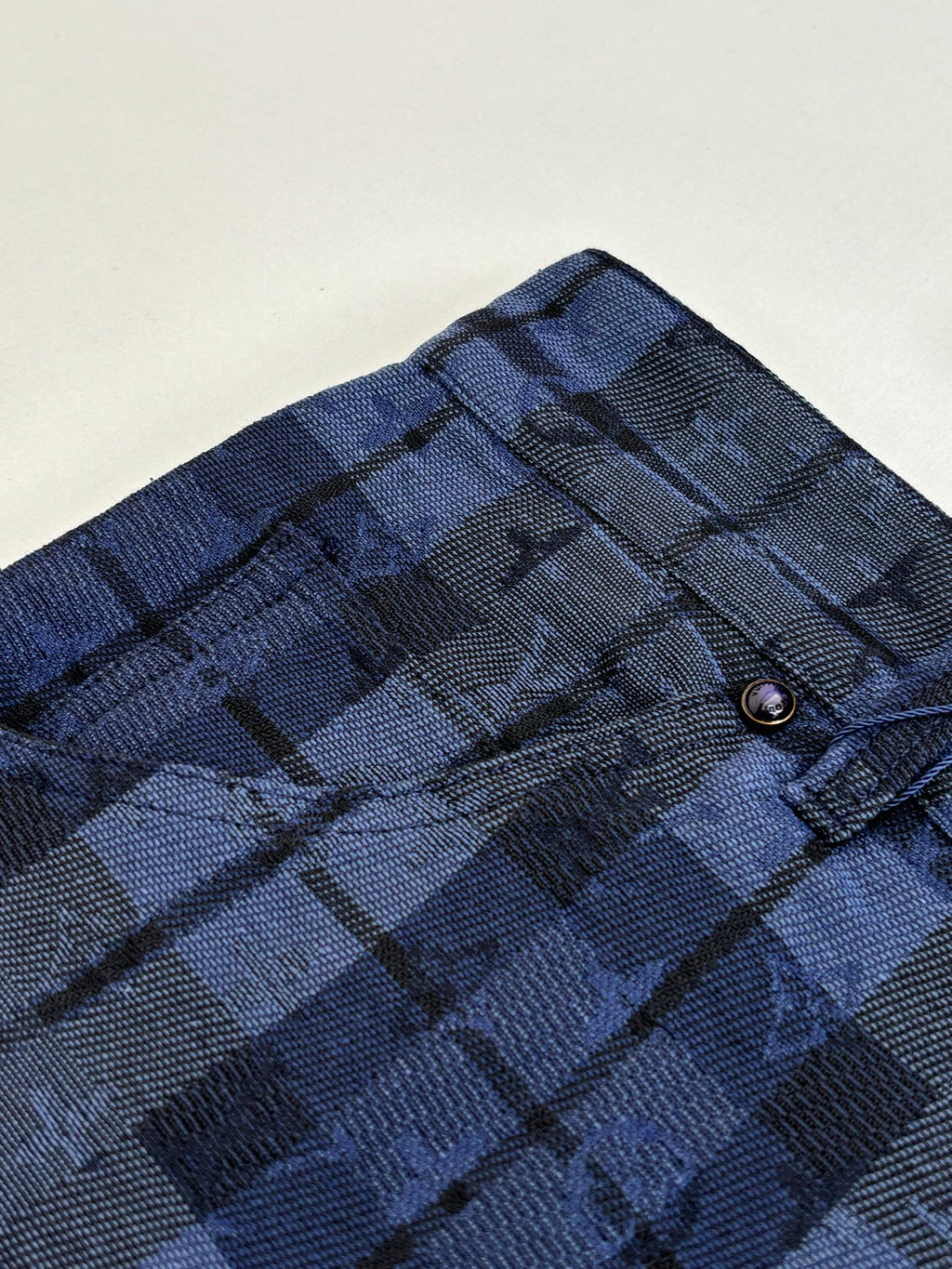 Dark blue plaid fabric with stitched waistband and belt loops detail