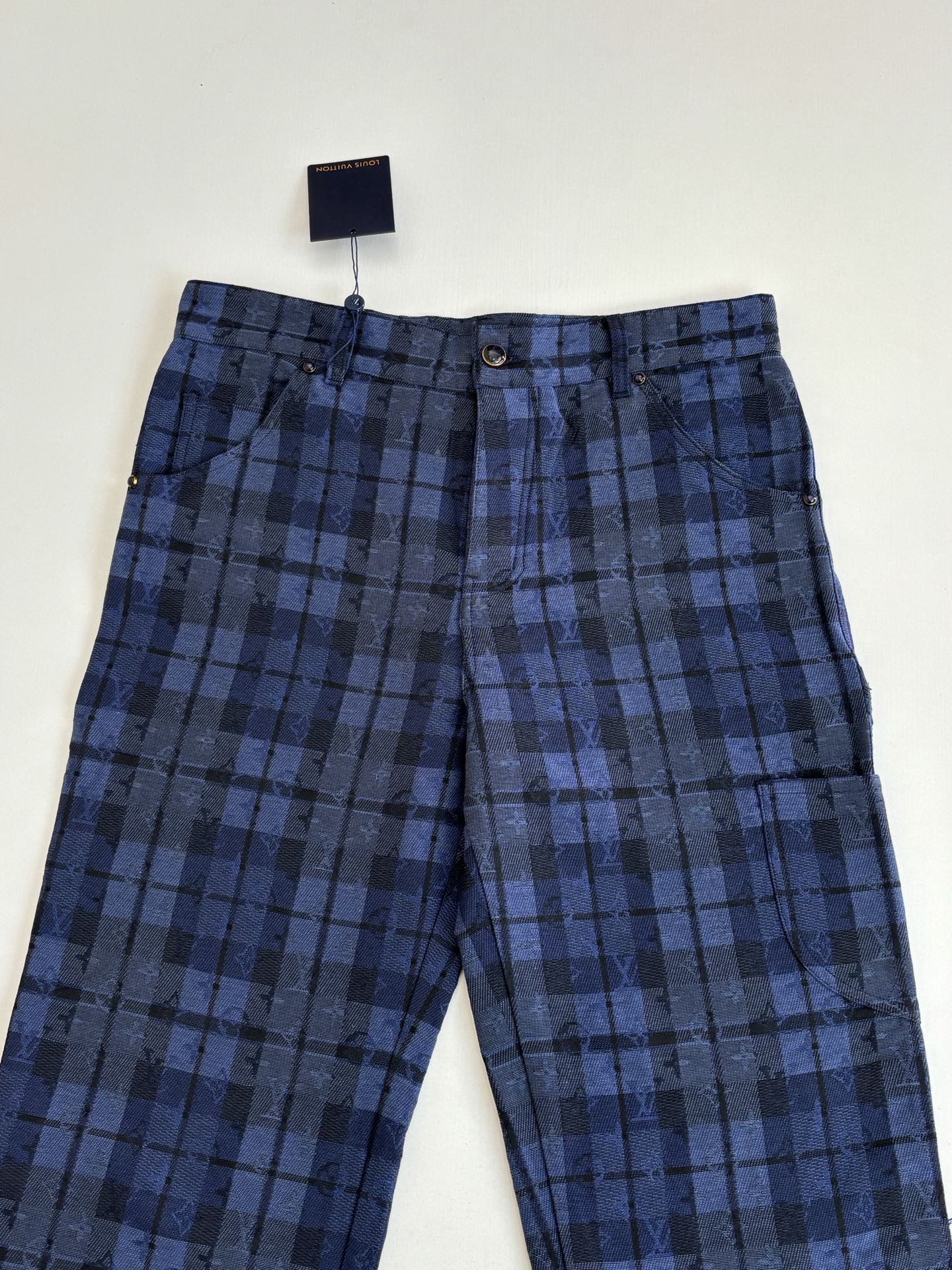 Dark blue plaid trousers with button waistband, belt loops, and side pockets