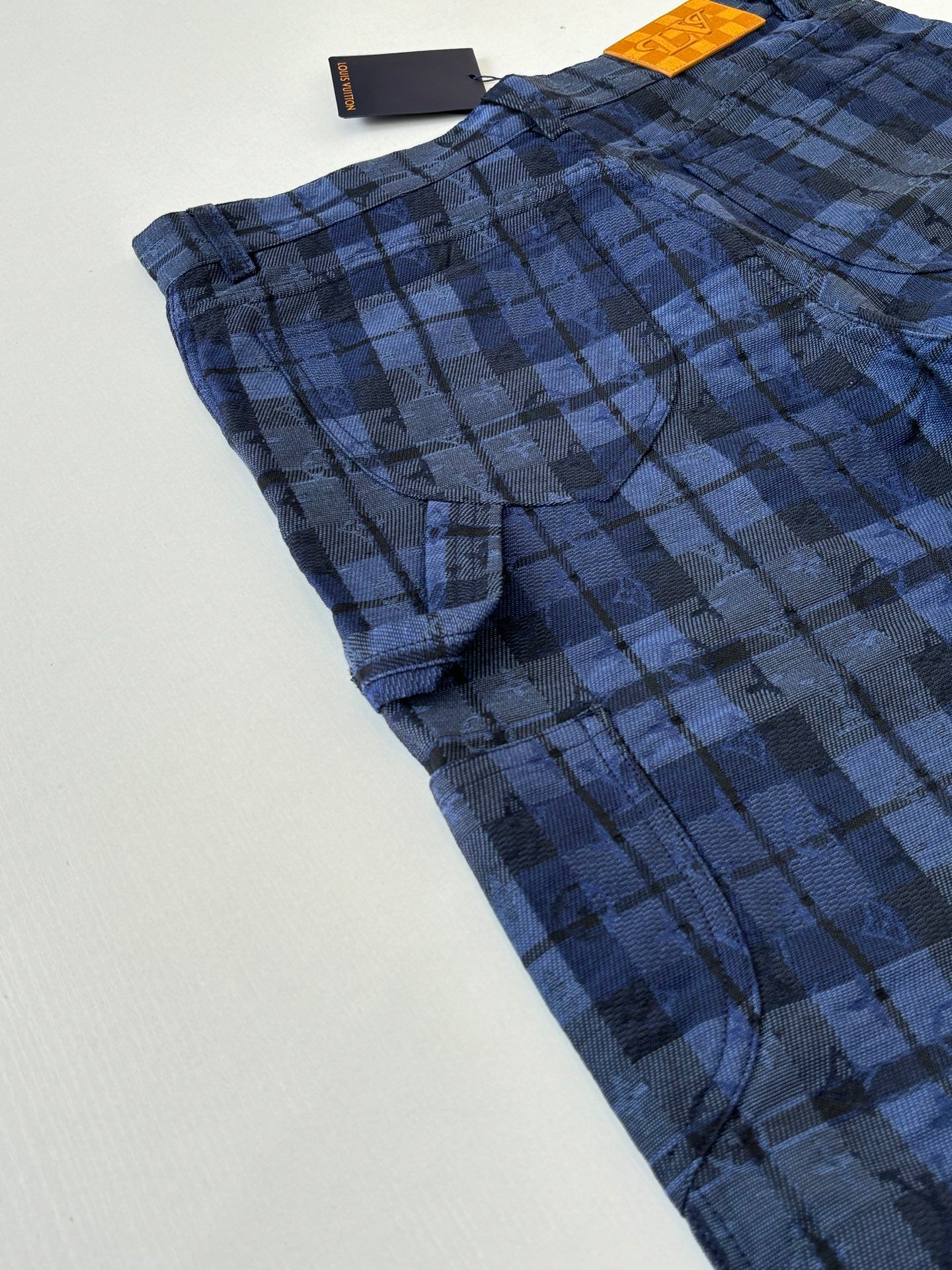 Dark blue plaid trousers with pleated front and curved side pocket