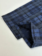 Blue plaid trousers leg with stitched pocket and folded cuff detail