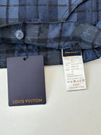 Blue plaid pants fabric close-up with Louis Vuitton size and care labels