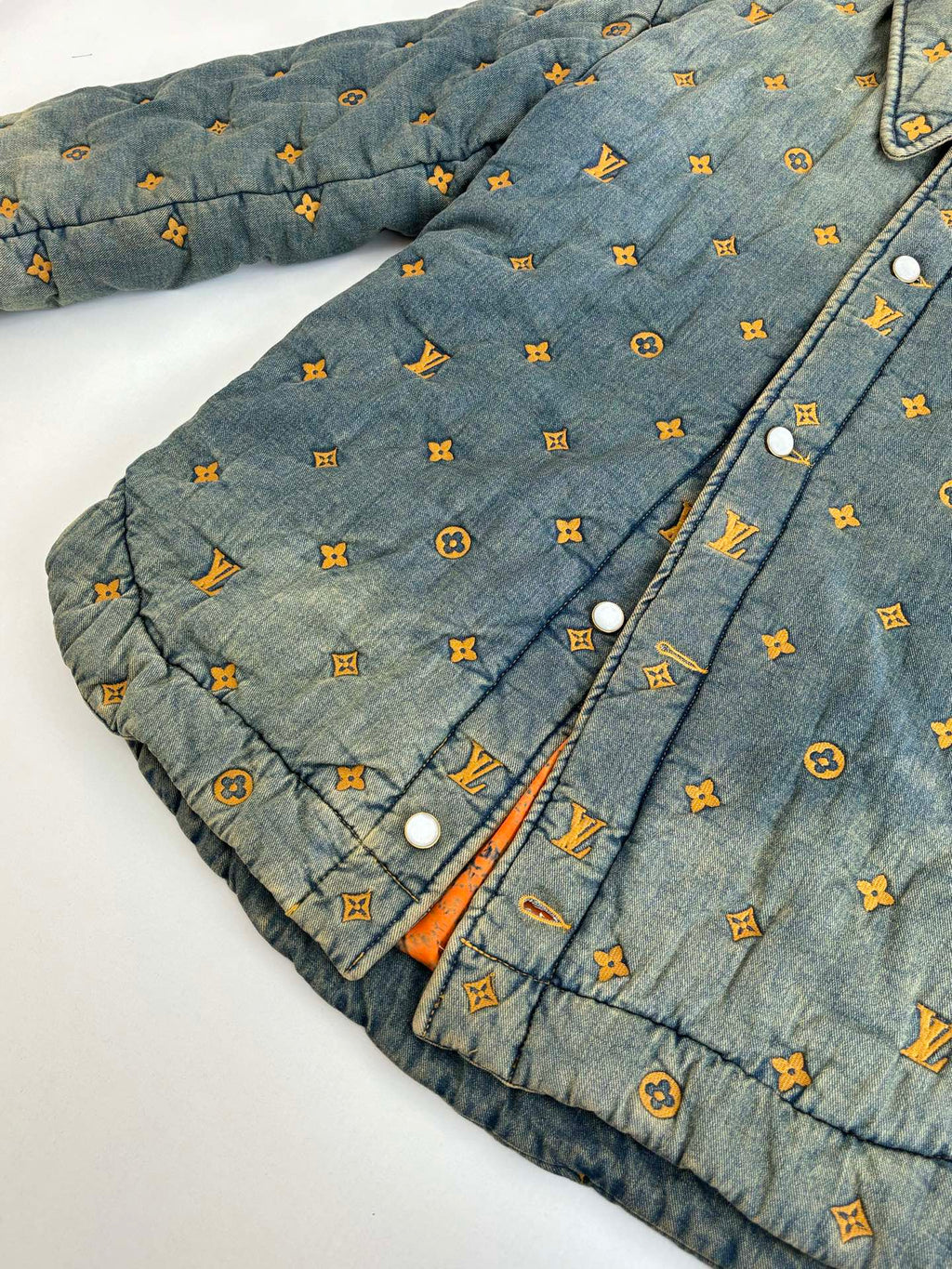 Louis Vuitton denim jacket front close-up with orange-ink monogram pattern and snaps