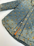 Louis Vuitton denim jacket front close-up with orange-ink monogram pattern and snaps