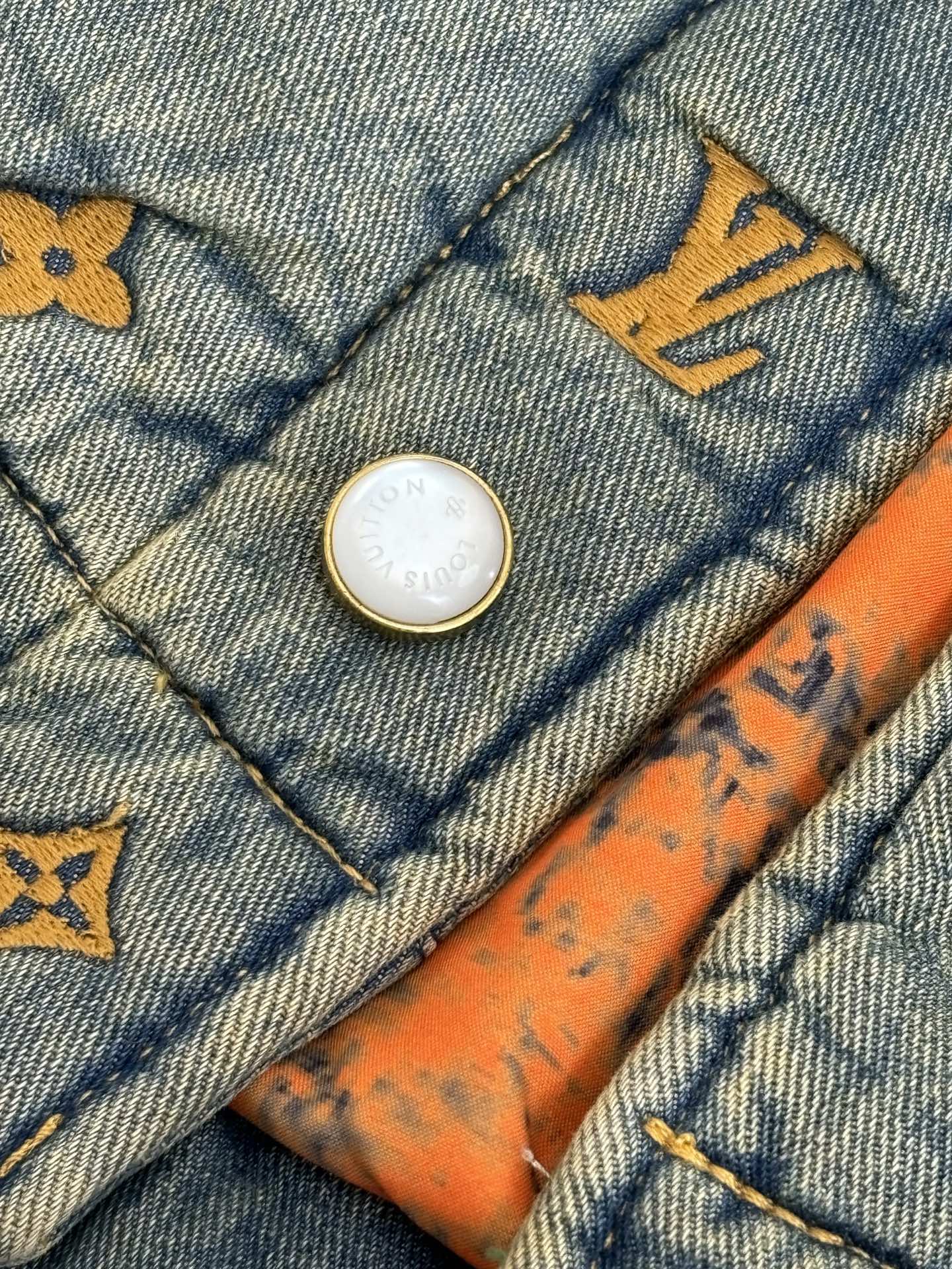 Louis Vuitton denim jacket button detail with yellow monogram trim and orange stitching