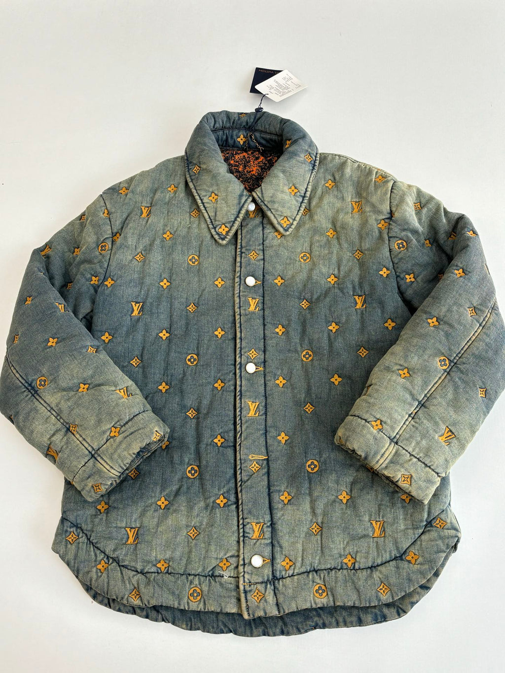 Louis Vuitton long denim jacket, front view with yellow monogram pattern and snap buttons