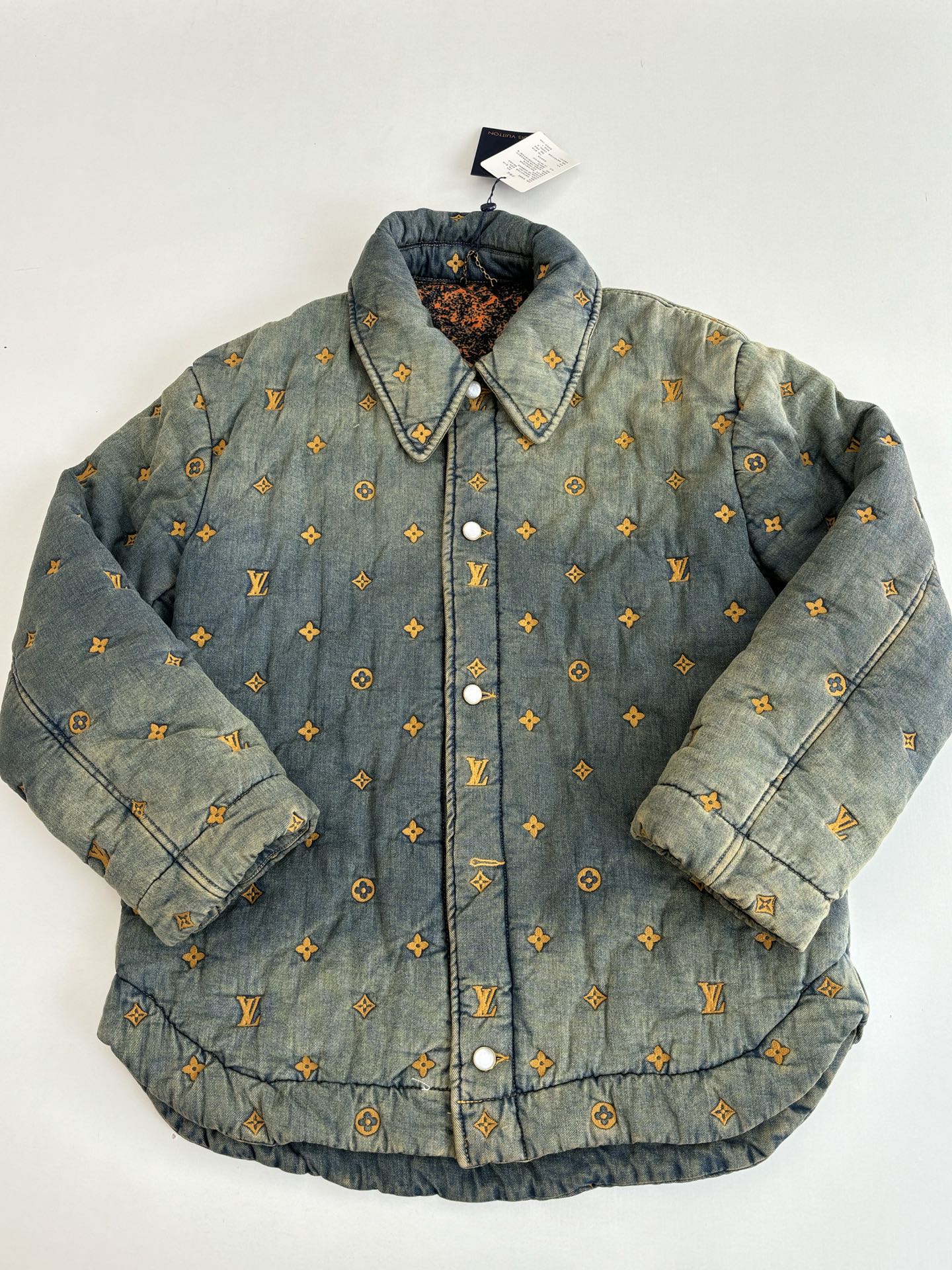 Louis Vuitton long denim jacket, front view with yellow monogram pattern and snap buttons