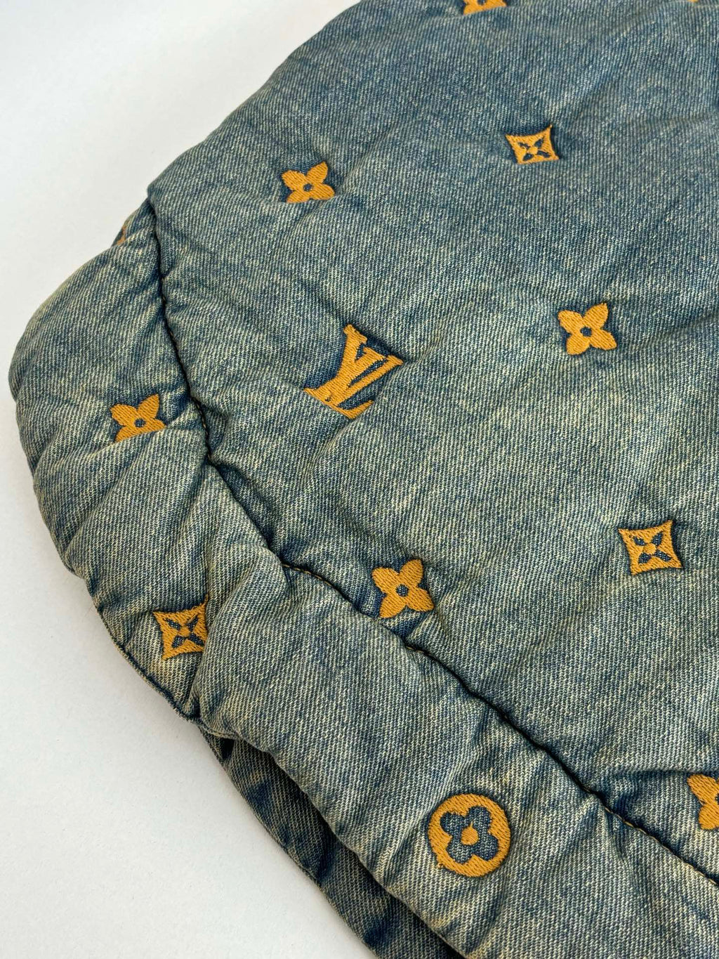 Louis Vuitton denim jacket sleeve close-up with yellow and orange monogram icons