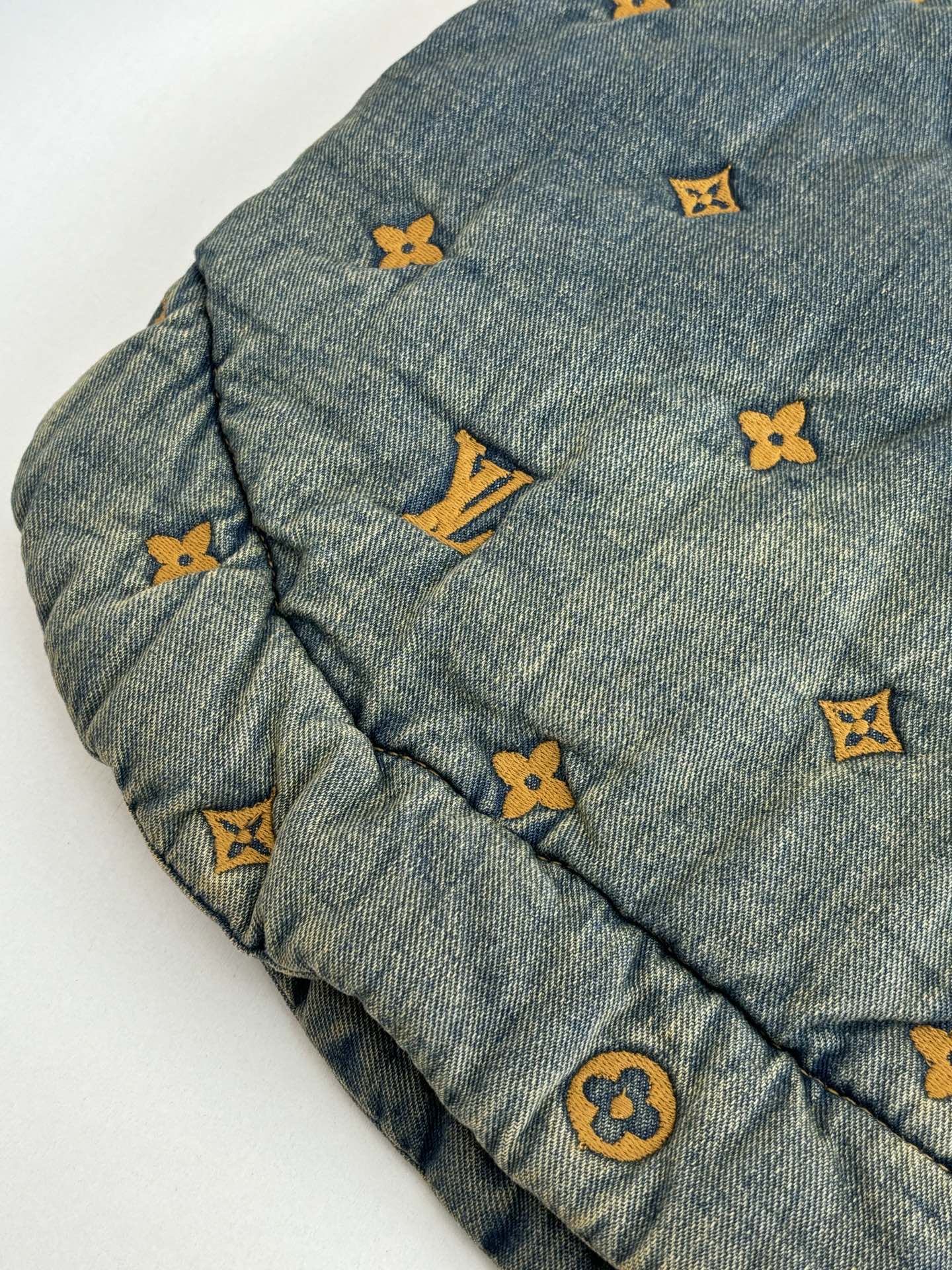 Louis Vuitton denim jacket sleeve close-up with yellow and orange monogram icons