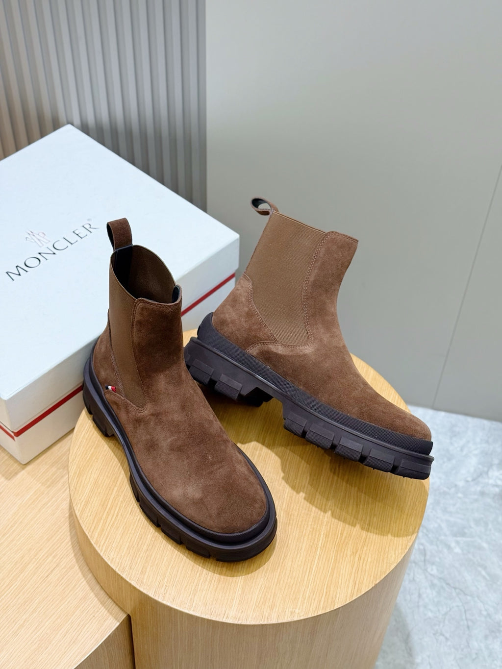 Moncler brown suede Chelsea boots on display pedestal with elastic side panels