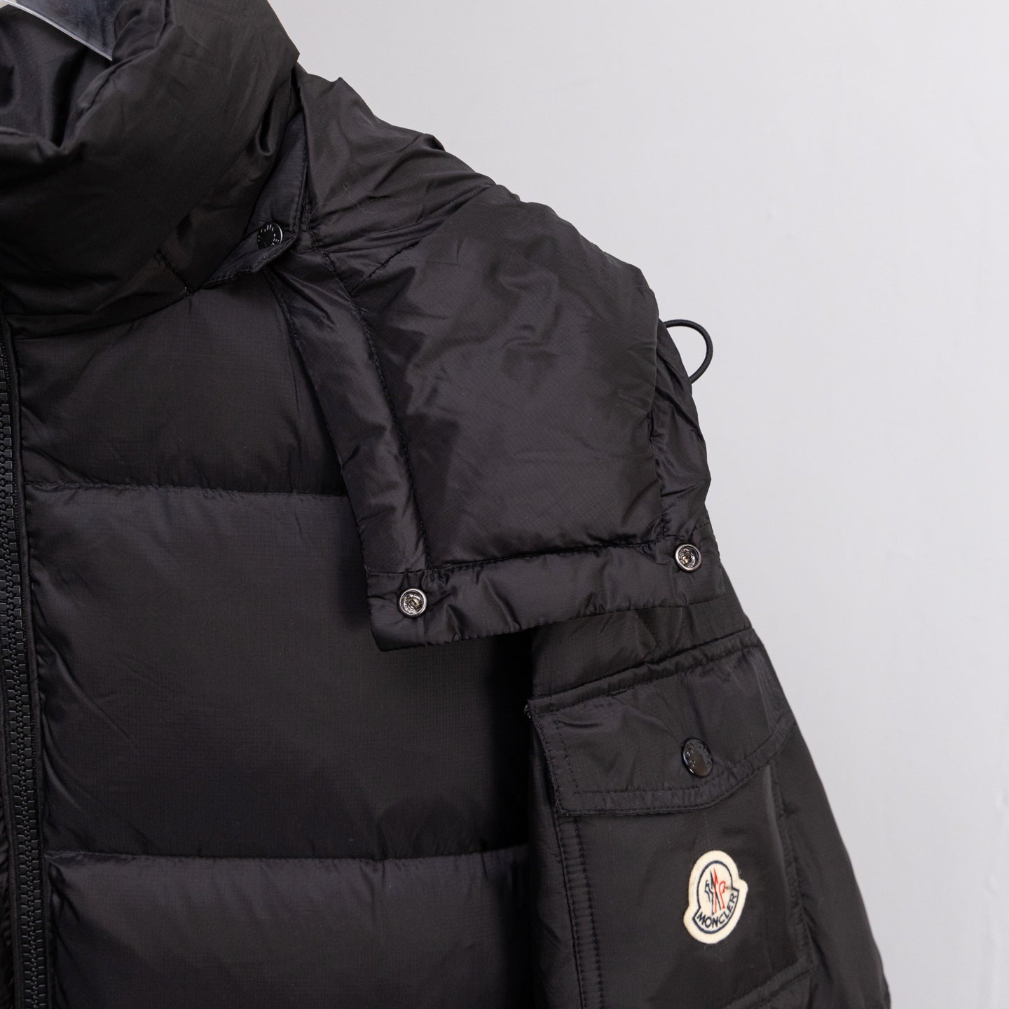 Moncler long puffer jacket sleeve with logo patch and buttoned pocket, black