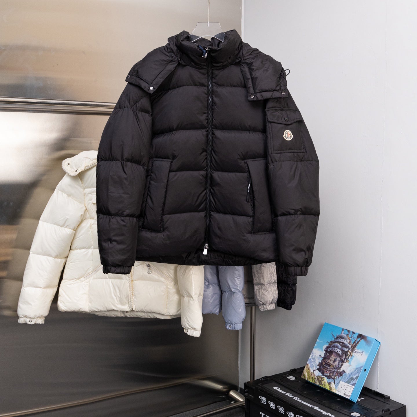 Moncler long puffer jacket with hood, front zipper, and buttoned pockets, black