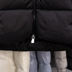 Long black puffer jacket, front zip and ruffled hem detail