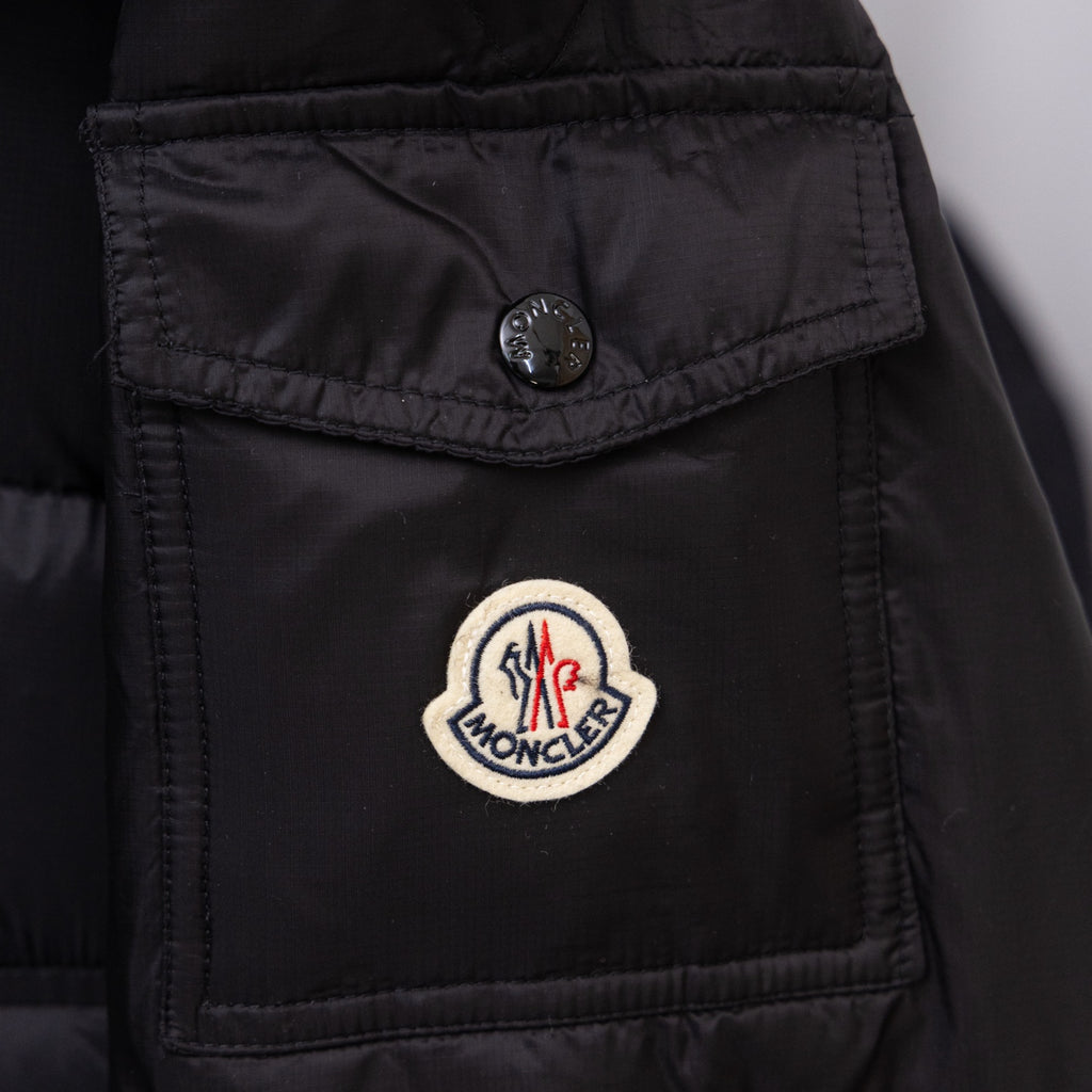 Moncler logo patch on black long puffer jacket chest