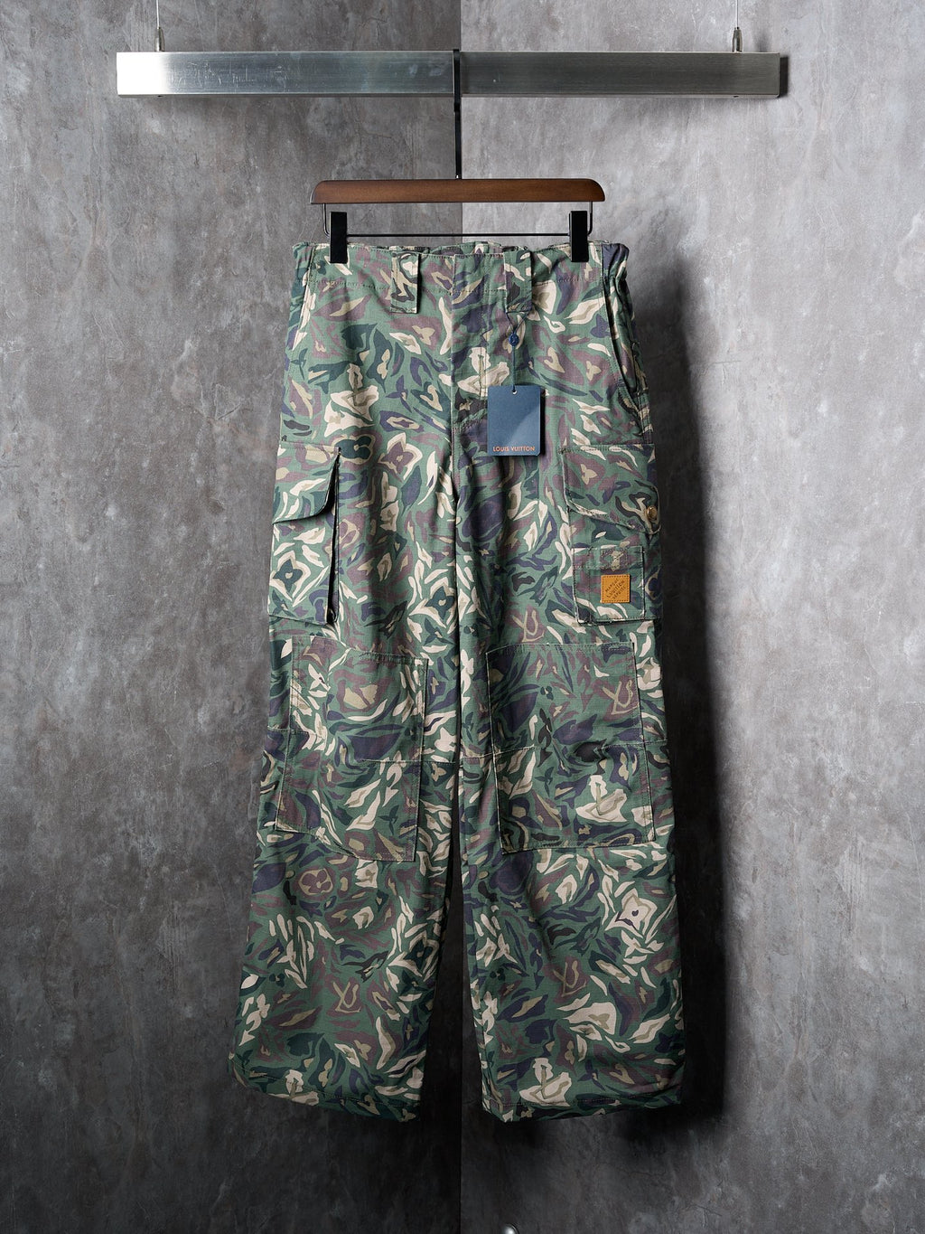 Louis Vuitton camouflage cargo pants on hanger with buttoned front and pockets