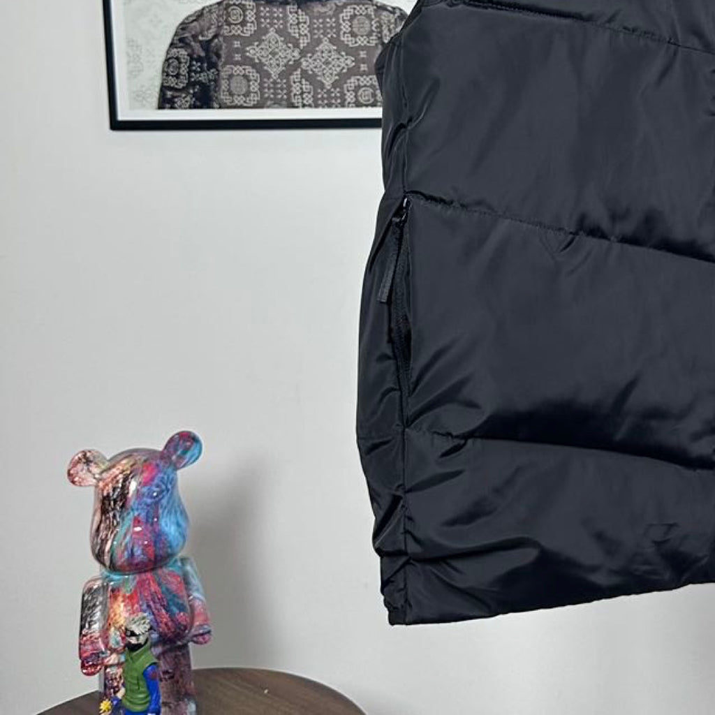 Moncler hooded puffer vest, side view, dark quilted panels and arm opening