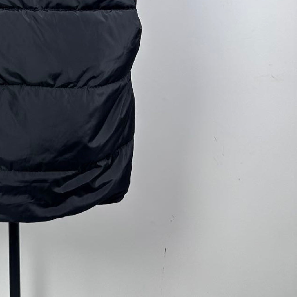 Dark black Moncler long puffer coat close-up with quilted horizontal stripes
