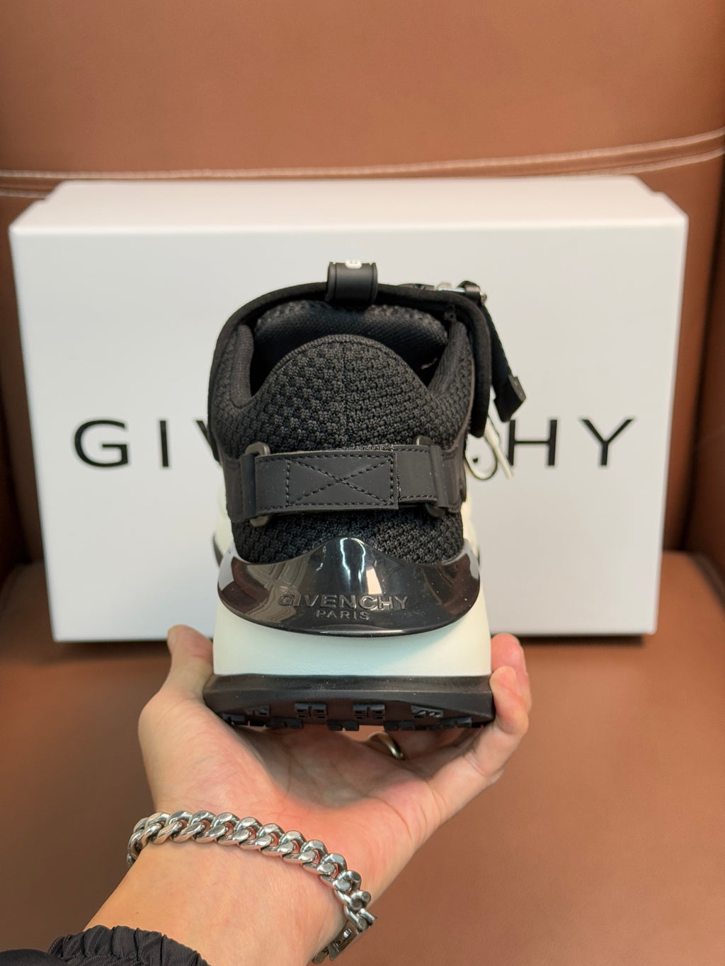 Luxury black sneakers heel close-up with strap closure and cushioned back collar
