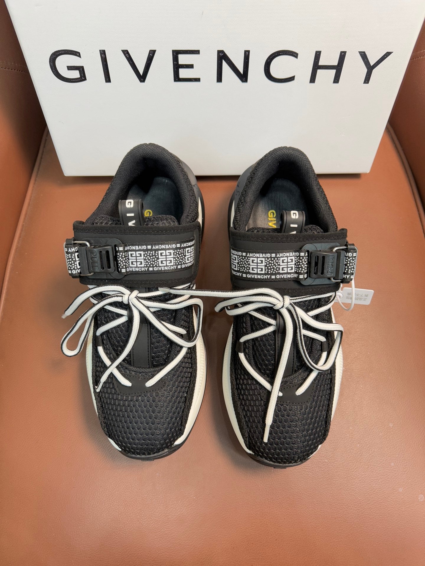 Luxury black knit sneakers with white soles, lace-up front, and logo strap details