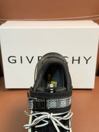 Luxury black sneakers close-up, lace-up with side strap and patterned logo on insole