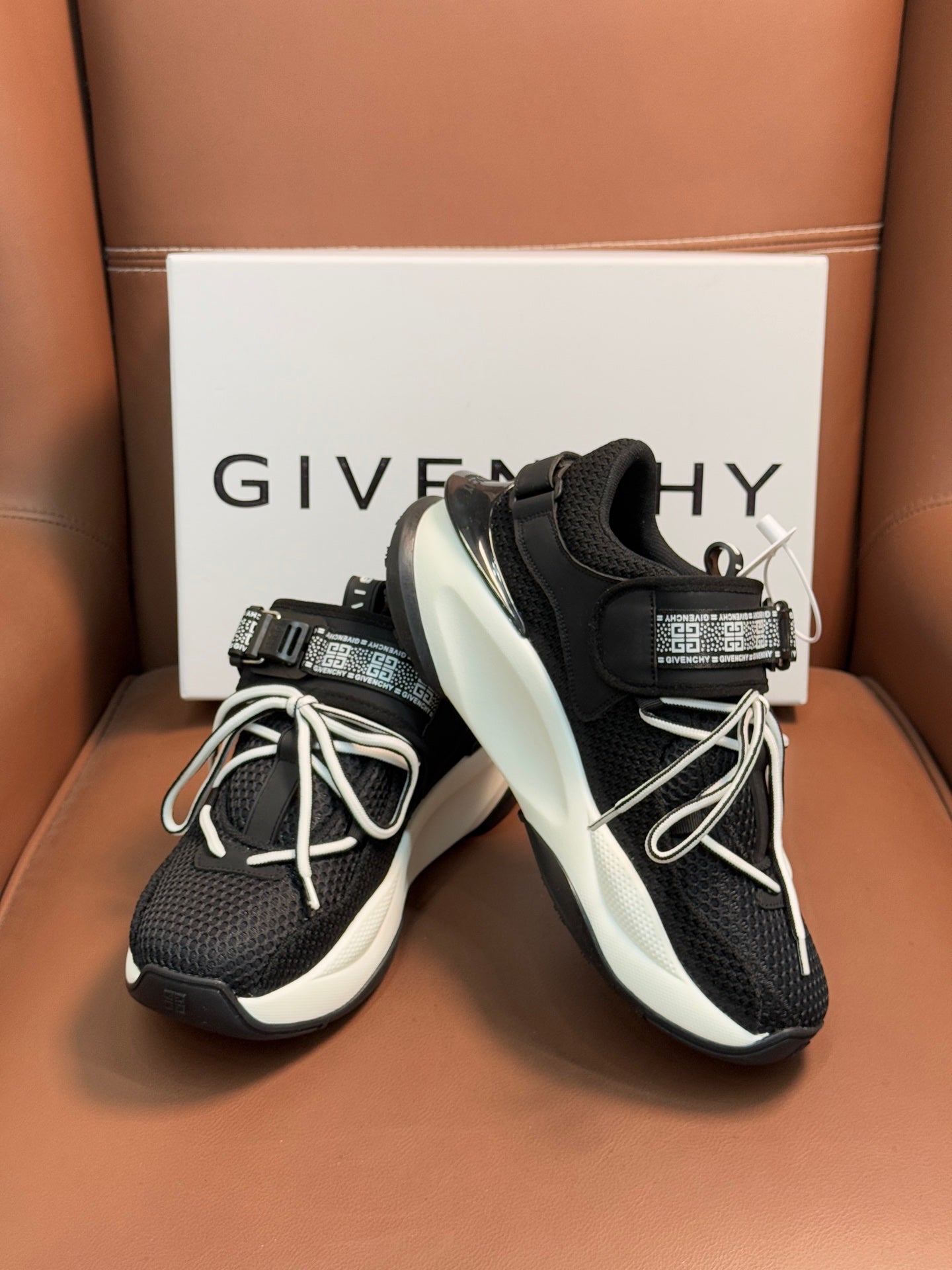 Luxury black sneakers with white soles, lace-up front, and padded collar with strap