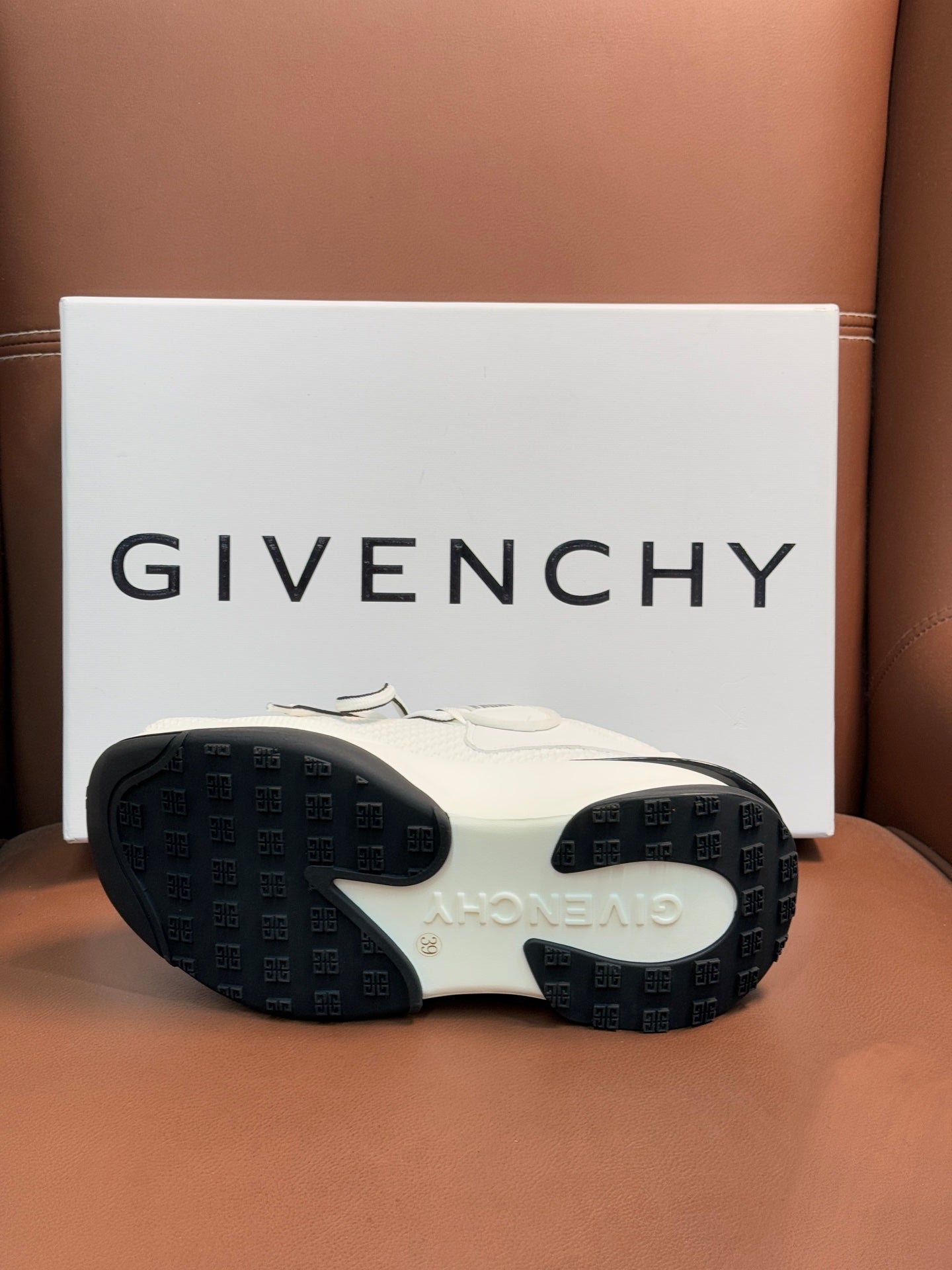 White sneaker soles with dark traction tread and logo text