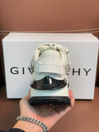White sneakers heel close-up with dark outsole and embossed side logos