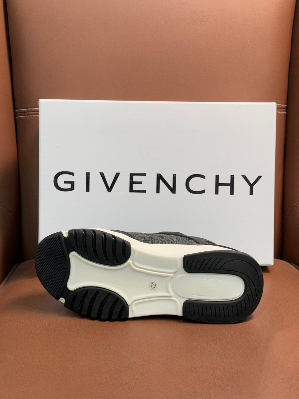 Dark gray sneaker outsole with textured rubber tread and white foam sole